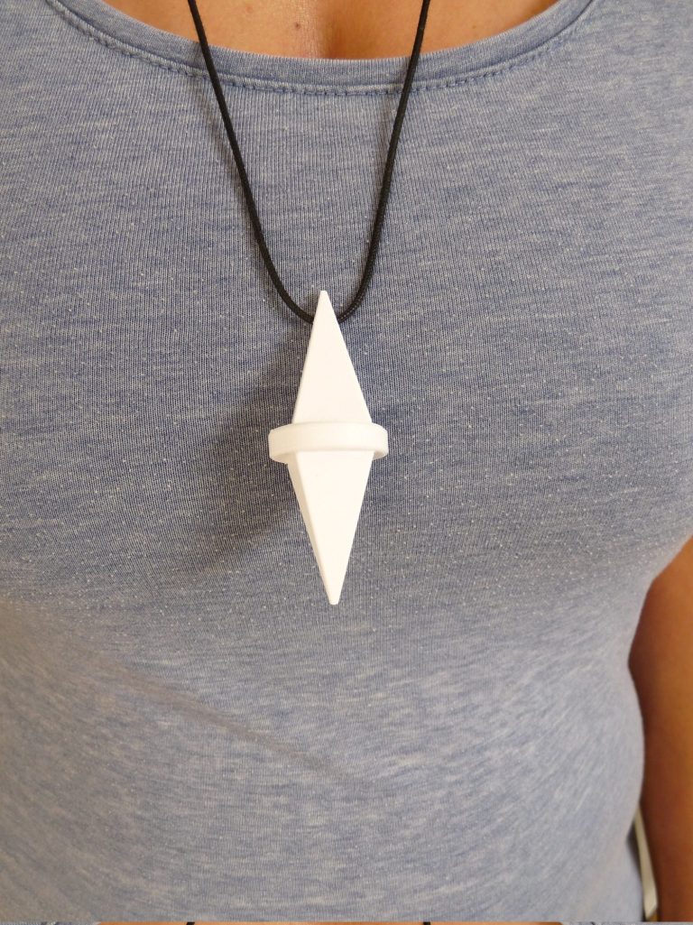 Die Tisch-Doppelpyramide steht auf einem Tisch mit Blumen und Mineralien